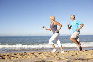 Older couple running on the beach