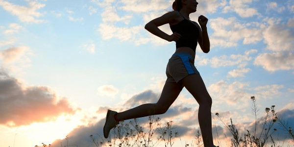 Silhouette woman run under blue sky with clouds